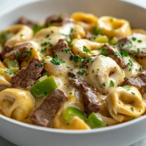 The blend of flavors in the cheesesteak tortellini with creamy provolone sauce offers a delightful culinary experience that combines classic Italian pasta with quintessential American flavors. The rich, savory elements of tender beef sirloin, sautéed onions, and green bell peppers enveloped in a luscious provolone cheese sauce create an exquisite dish that is luxurious yet accessible. Perfect for a comforting weeknight dinner, this recipe allows you to indulge in the beloved components of a traditional cheesesteak in a unique pasta form.